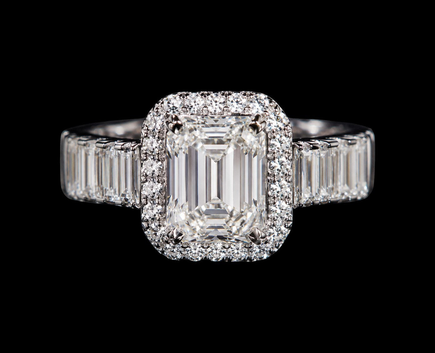 Petey's jewelry emerald-cut moissanite engagement ring with a halo of small diamonds and baguette side stones, set in silver.