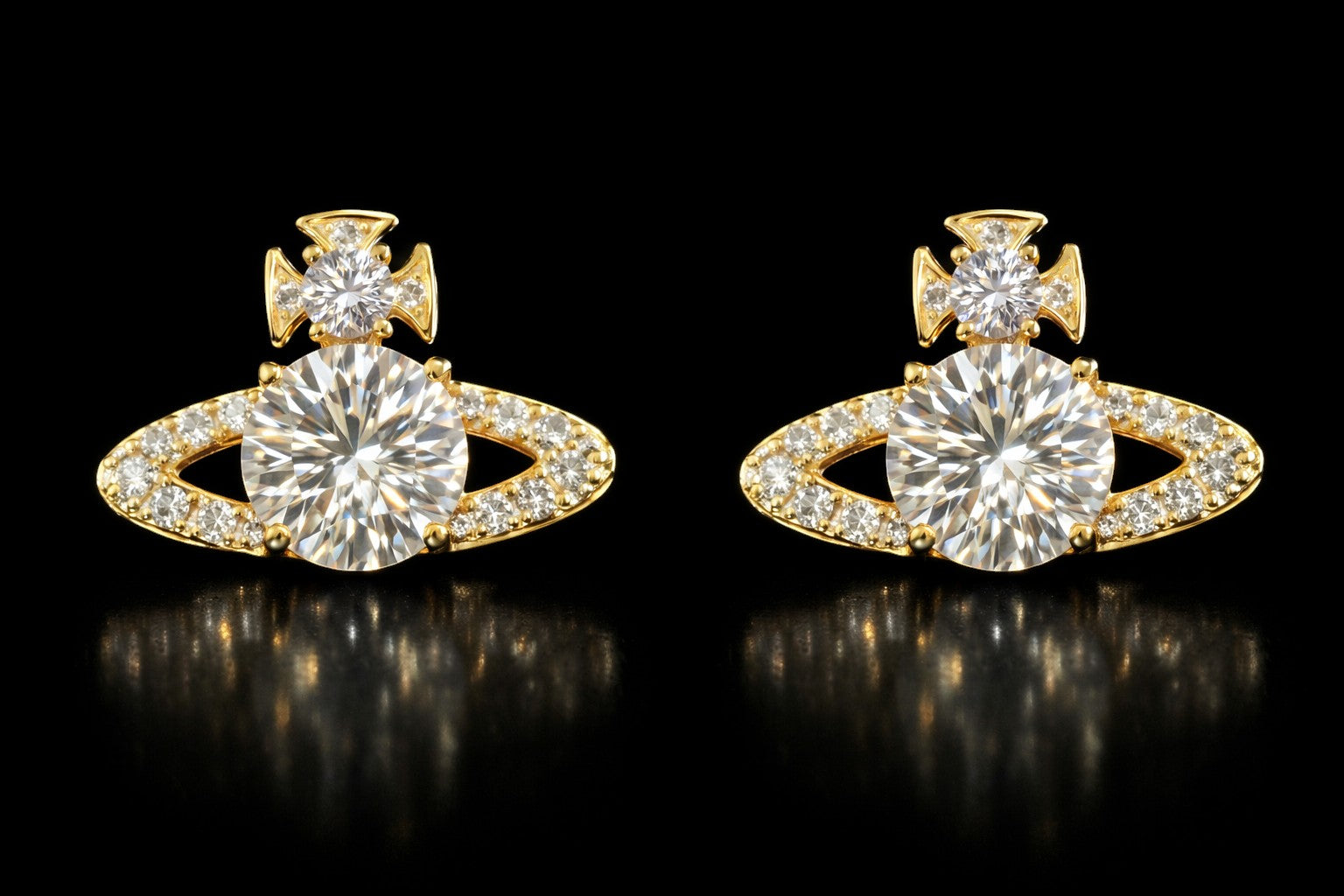 Petey's jewelry gold-tone planet stud earrings with VVS moissanite stones and cross detail on a black background.