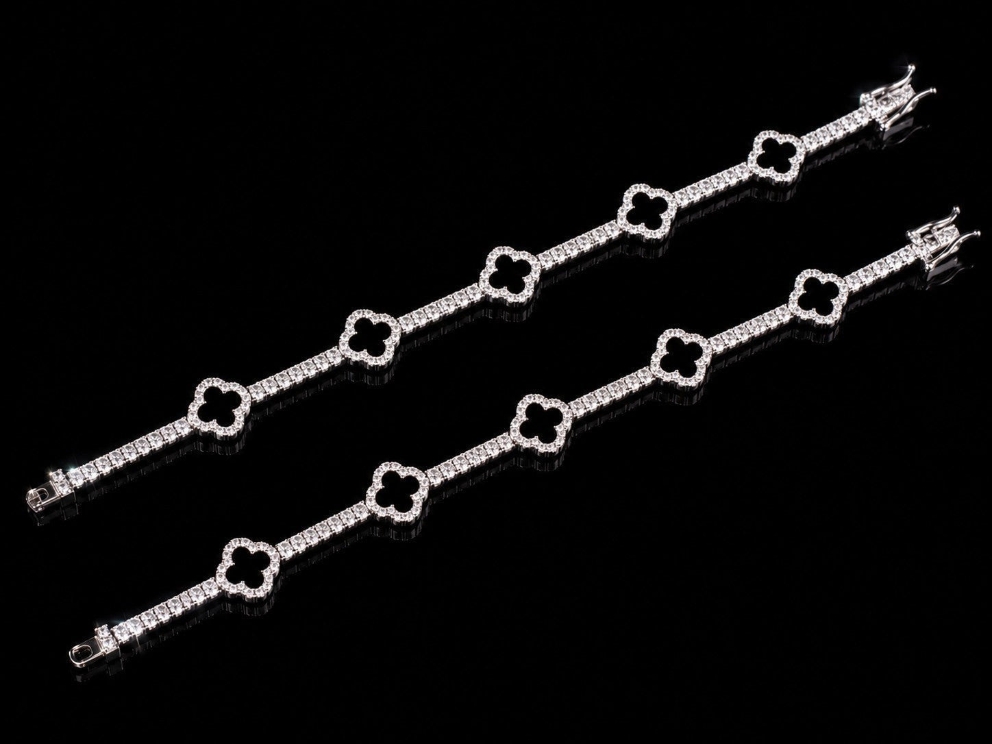 Petey's jewelry 925 sterling silver clover tennis bracelet with iced out VVS moissanite diamonds on a black background