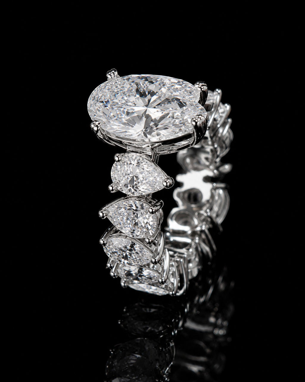 Petey's jewelry luxurious women's 925 silver ring with VVS moissanite stones in oval and pear cuts, prong-set on a black background.