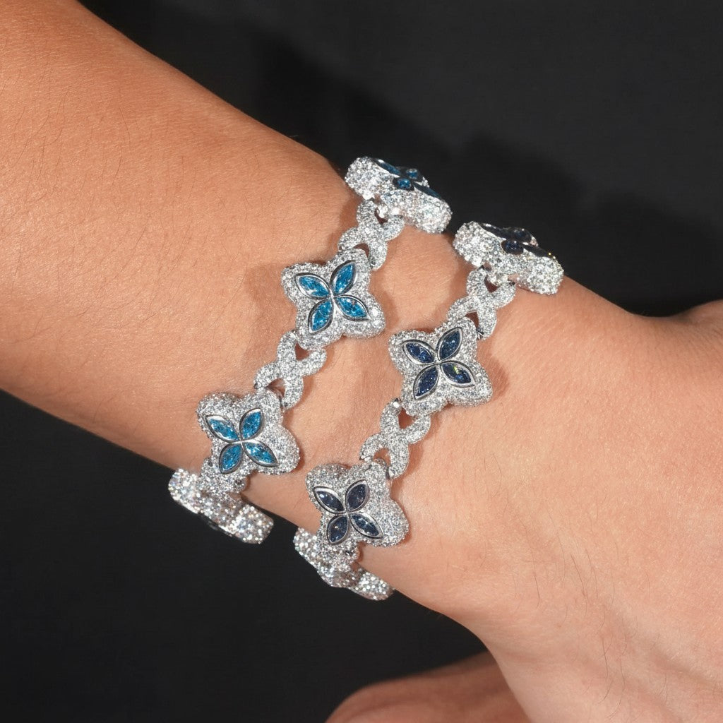 Petey's jewelry iced out 925 sterling silver bracelet featuring blue moissanite clover links on a wrist.