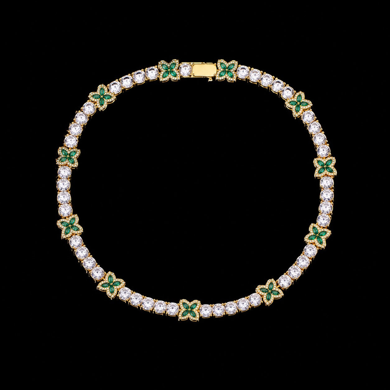 Petey's jewelry iced out tennis chain featuring alternating clear round and green four-leaf clover zircon stones.