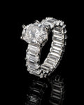 Petey's jewelry luxury women's ring with a large round VVS moissanite center stone and a band of baguette-cut moissanite stones.